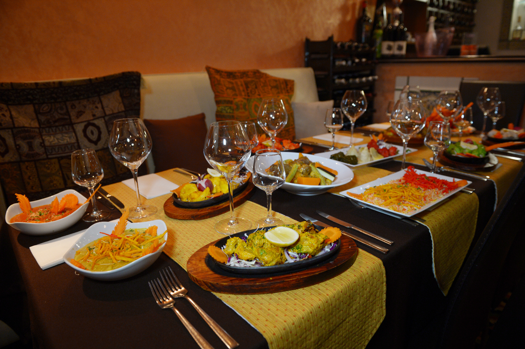 A table in a restaurant full of Indian dishes