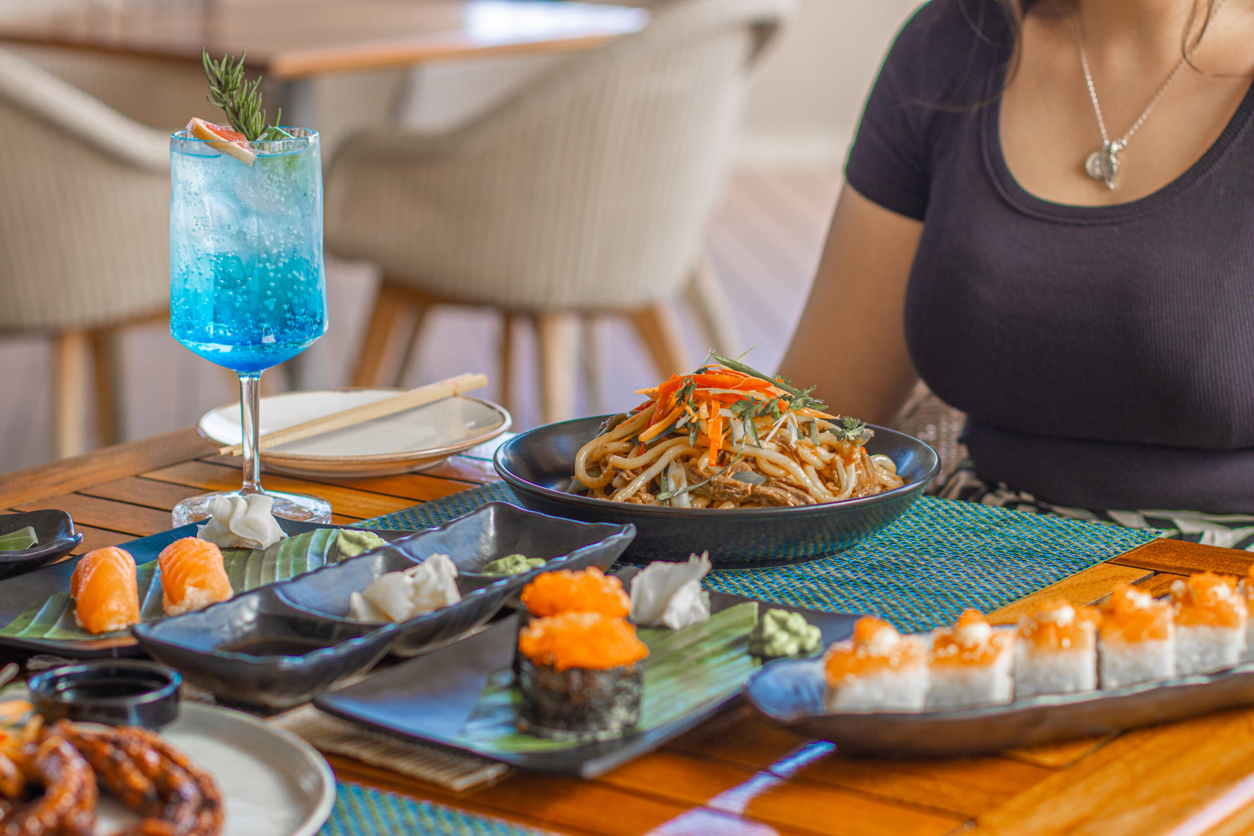 Plates sushi and noodles at a restaurant table