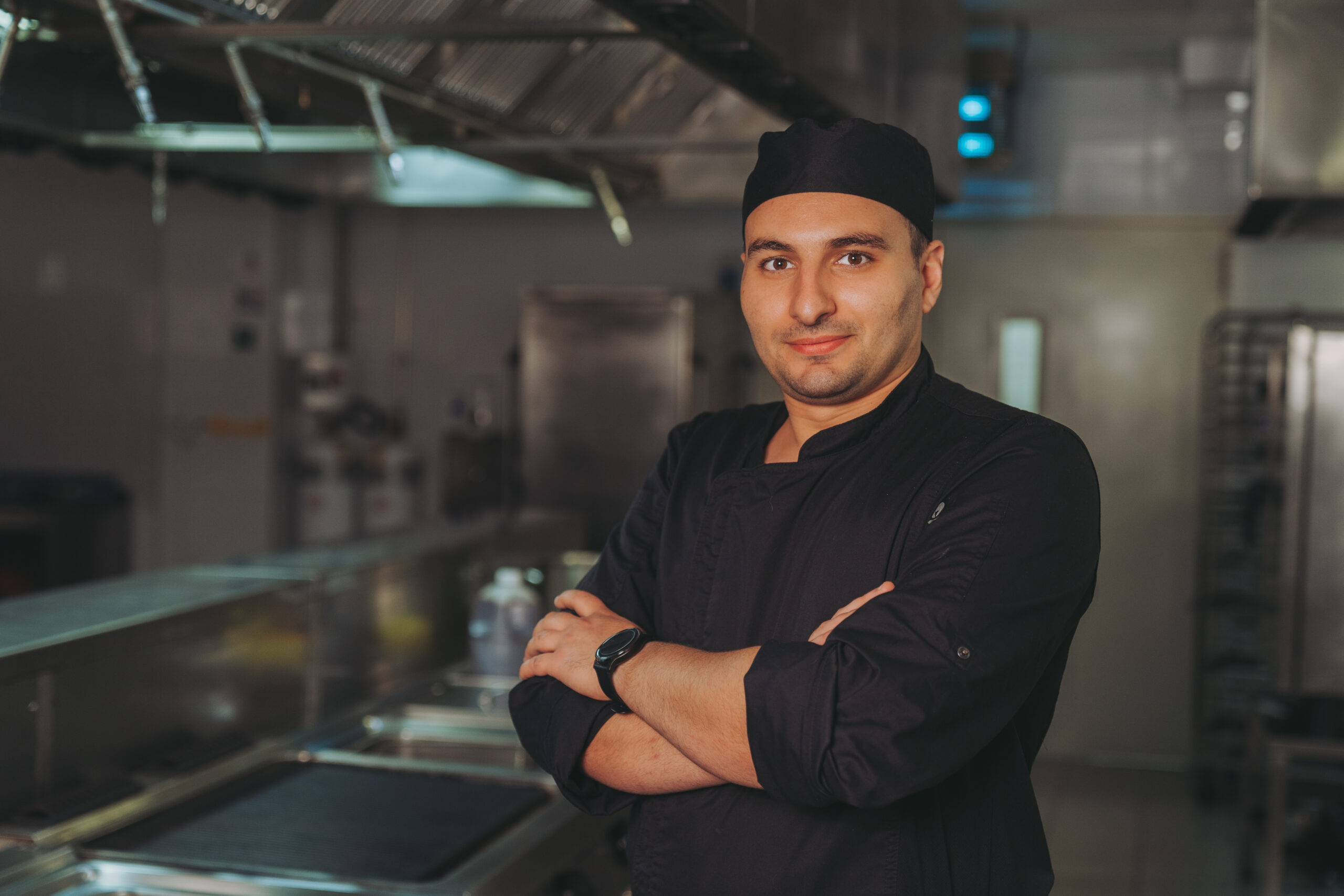 Chef Steven Pisani from The Orchard, standing in a kitchen with his arms crossed